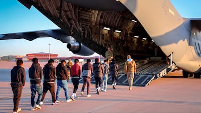 Migrantes ingresando a un avión para un vuelo de deportación
