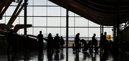 Varias personas atraviesan la terminal T 4 del Aeropuerto Adolfo Su&aacute;rez-Madrid Barajas en Madrid.