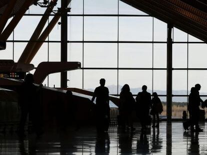 Varias personas atraviesan la terminal T 4 del Aeropuerto Adolfo Su&aacute;rez-Madrid Barajas en Madrid.