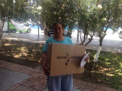 Una mujer sostiene el televisor que el Gobierno mexicano entrega.
