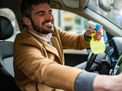 Un hombre limpiando el salpicadero del coche con un gel abrillantador.