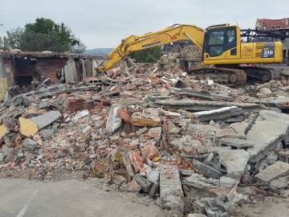 Excavadora de la empresa de desamiantado, sobre el mar de escombros de la zona cero de Paramos.