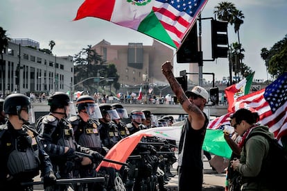 Manifestantes ondean banderas de México y Estados Unidos frente a agentes de la Patrulla de Carreteras de California, durante las protestas del 'No kings day'.