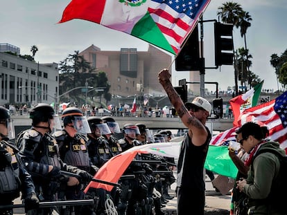 Manifestantes ondean la bandera de México y Estados Unidos frente a policías de California, en el centro de los Ángeles, el sábado pasado.