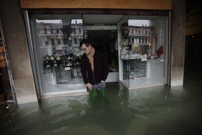 Un hombre camina junto al escaparate de una tienda inundada en Venecia, este viernes.