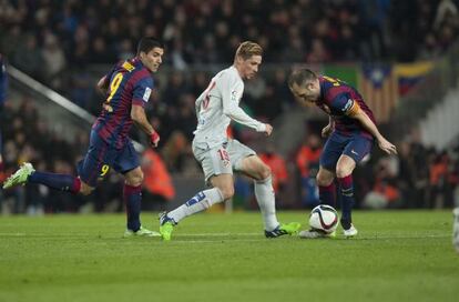 Fernando Torres controla un balón ante Iniesta y Luis Suárez.