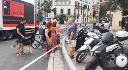 Vecinos intentando cruzar la calle de Aragó con avenida Meridiana a las 14 horas, cuando se instalaban las últimas vallas en el trazado de la contrarreloj de La Vuelta.