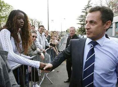 El presidente saluda a una seguidora a su llegada a un polideportivo cercano a París.