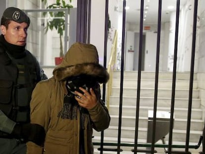 Un guardia civil conduce a un sospechoso fuera de las instalaciones del banco chino ICBC en Madrid.