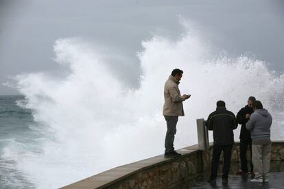 En el resto de la Península se prevén intervalos nubosos y no se descarta alguna precipitación débil ocasional y aislada. Mientras, en Canarias los cielos estarán nubosos o con intervalos nubosos y no se descarta alguna precipitación ocasional en las islas centrales. En la imagen, varias personas, en el Passeig Marítim Rafael Casanova de Tarragona, fotografían el temporal que está afectando a Cataluña.