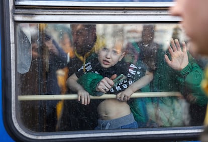 Una mujer huye con su hijo en tren de Kiev a Lviv, en el oeste de Ucrania, cerca de la frontera con Polonia, este sábado.