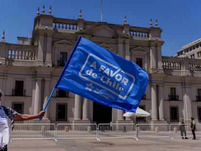 Un hombre ondea una bandera de la campaña por la opción 'a favor', el 6 de diciembre frente a La Moneda.