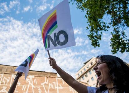 Una mujer porta una bandera de repudio a Pinochet a 30 años del plebiscito que puso fin a la dictadura.