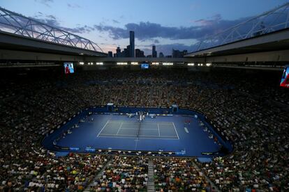 El sol se pone sobre la ciudad del distrito central de negocios de Melbourne durante el partido entre Rafael Nadal y Bernard Tomic.