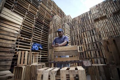 Un trabajador repara cajas de madera ('huacallis').