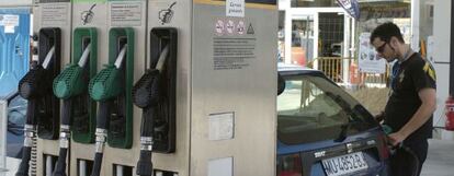 Un hombre pone gasolina a su coche en un surtidor de una gasolinera
