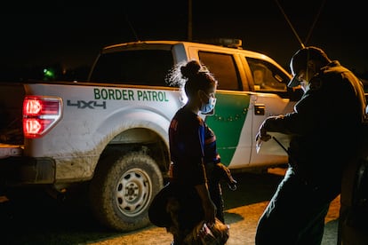 Un oficial de la patrulla fronteriza procesa a una mujer migrante después de cruzar el Río Grande hacia Texas (EE UU).