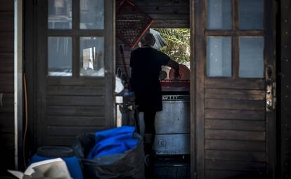 Una mujer prepara el lavavajillas en la parte trasera de la cocina de en un chiringuito de Playa de Aro (Costa Brava)