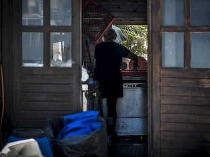 Una mujer prepara el lavavajillas en la parte trasera de la cocina de en un chiringuito de Playa de Aro (Costa Brava)