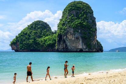 Una familia caminando por la playa tailandesa de Railay.