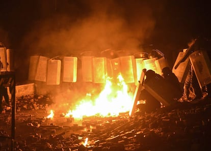 La policía antidisturbios se protege de un cóctel molotov durante los enfrentamientos con un grupo de manifestantes en el centro de Kiev (Ucrania), 19 de enero de 2014.