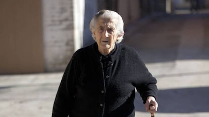 Una anciana pasea por la calle.