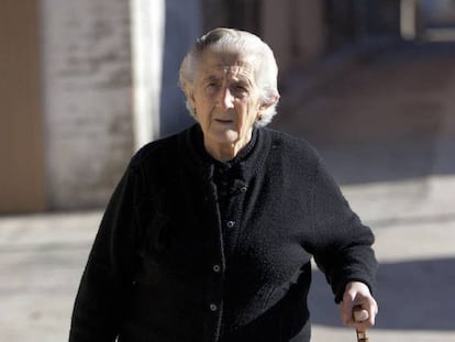 Una anciana pasea por la calle.