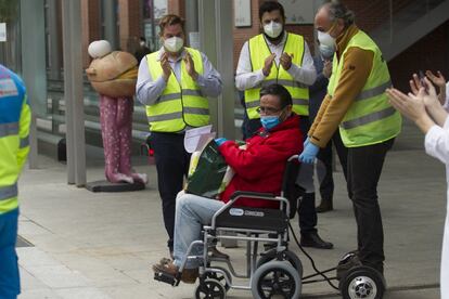 Un enfermo por coronavirus recibe los aplausos de un grupo de personas tras ser dado de alta en el hospital de campaña del Ifema, este sábado.