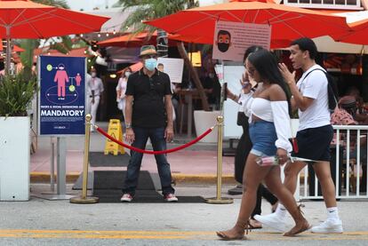 Un hombre vigila la entrada de un restaurante en Miami Beach, Florida (EE UU). El Departamento de Salud de Florida ha informado este sábado de más de 10.300 casos nuevos de coronavirus en las últimas 24 horas. El balance detalla 10.328 nuevos contagios por el virus y 90 decesos más en las últimas horas, que elevan el total de casos a 337.569. El número total de fallecidos en el Estado del sur de EE UU es de 4.895.