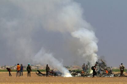 Combatientes rebedles inspeccionan los restos de un helicóptero ruso que ha sido derribado en el norte de Siria. 