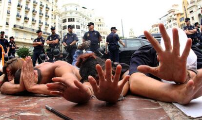 Un grupo de indignados protesta ante la policía en la plaza del Ayuntamiento de Valencia.