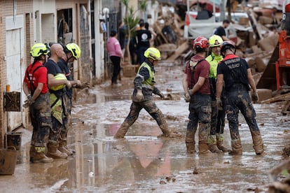 Efectivos del cuerpo de bomberos trabajan en la limpieza y retirada del lodo en Alfafar (Valencia), este viernes.