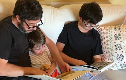 El escritor Samuel Alonso leyendo con sus dos hijos en su casa.