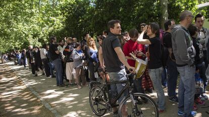 Asistentes a la Feria del Libro de Madrid hacen cola para una firma de ejemplares.