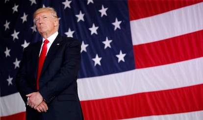 Donald Trump posa junto a una bandera de Estados Unidos
