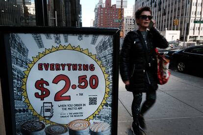 Un peatón pasa por delante de una oferta en una cafetería en Nueva York