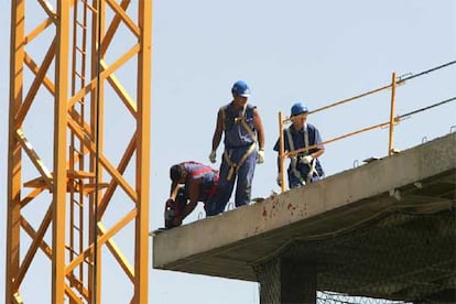 Varios obreros trabajan con el arnés puesto, pero sin estar sujetos a un elemento fijo, en una obra del polígono industrial de Alcobendas.