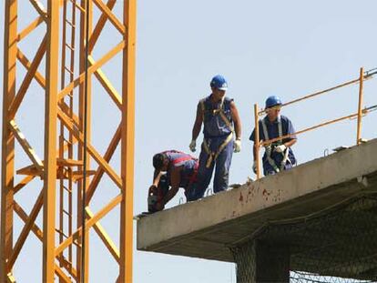 Varios obreros trabajan con el arnés puesto, pero sin estar sujetos a un elemento fijo, en una obra del polígono industrial de Alcobendas.