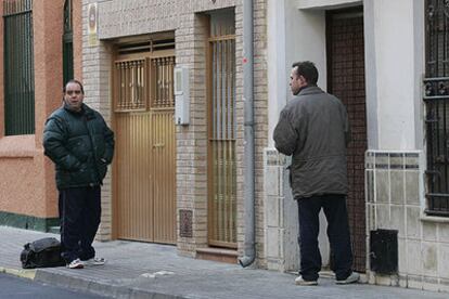 Dos familiares de la chica asesinada en la puerta de su casa, el lugar en el que ocurrió el suceso.