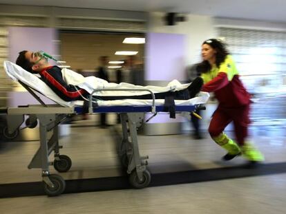 Una sanitaria empuja la camilla de un enfermo en el hospital de Getafe (Madrid), centro de referencia par quemados críticos. / Gorka Lejarcegi