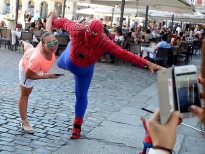 El Spiderman Gordo de la plaza Mayor, durante una actuaci&oacute;n con una turista.