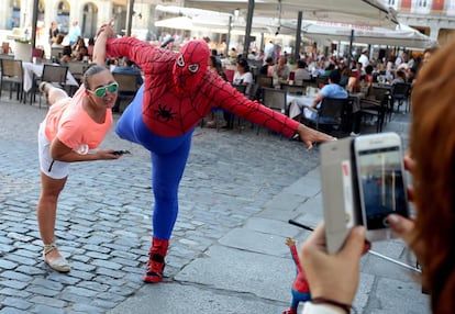 El Spiderman Gordo de la plaza Mayor, durante una actuaci&oacute;n con una turista.