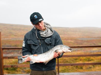 Un pescador sostiene un salmón fugado de una piscifactoría