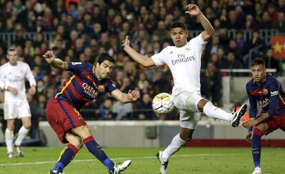 Casemiro intenta detener el disparo de Suárez.
