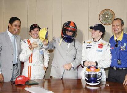 El presidente de Brasil, en el centro con casco, bromea con el ex campeón mundial de Fórmula 1, Emerson Fittipaldi, a su izquierda y miembros de su gabinete