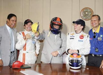 El presidente de Brasil, en el centro con casco, bromea con el ex campeón mundial de Fórmula 1, Emerson Fittipaldi, a su izquierda y miembros de su gabinete