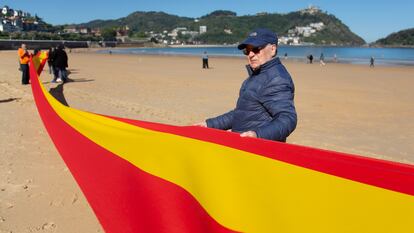 Votantes de Vox despliegan una bandera española en la playa de La Concha en San Sebastián, este viernes.