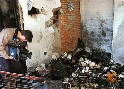 Un cámara de TV capta imágenes en una de las habitaciones del piso calcinado por las llamas en Coria del Rio.