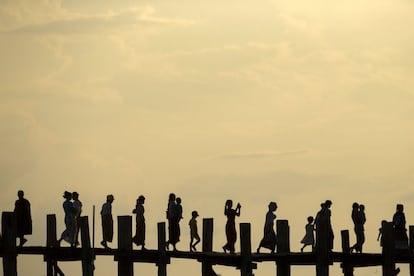 Un grupo de personas cruza el puente U Bein. Se trata de la plataforma de teca (madera) más larga del mundo. Se encuentra situada en el lago Tuangthaman, en Mandalay (Myanmar).