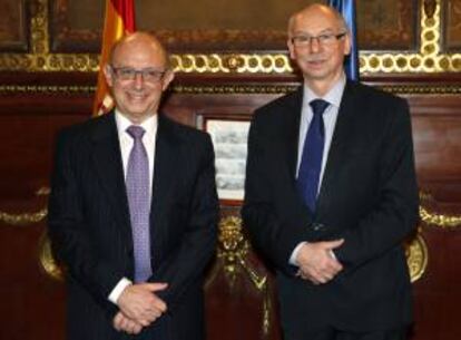 El ministro de Hacienda, Cristóbal Montoro (i), posa junto al comisario europeo de Programación Financiera y Presupuestos, Janusz Lewandowski, momentos antes de la reunión que ambos han mantenido hoy en la sede del ministerio, en Madrid.